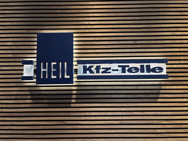Heil & Sohn Logo auf einer hölzerneren Wandverkleidung  